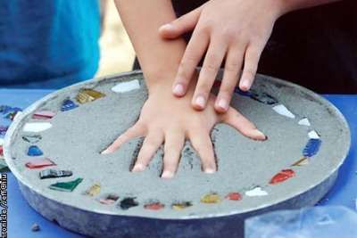 Person adding a personal touch to their garden stepping stones