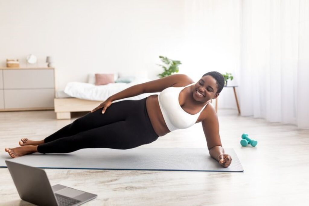 Woman side planking on a training mat