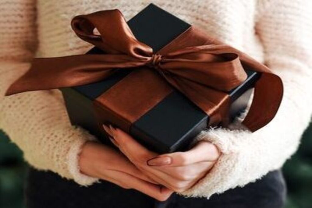 A woman clutching a black gift box