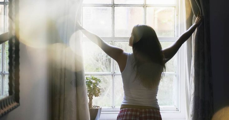 Woman Opening Curtains For Light