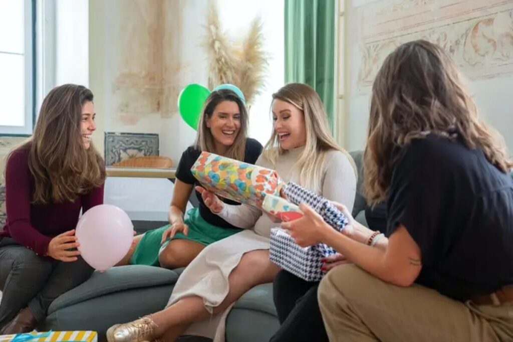 A woman being presented with a gift by friends