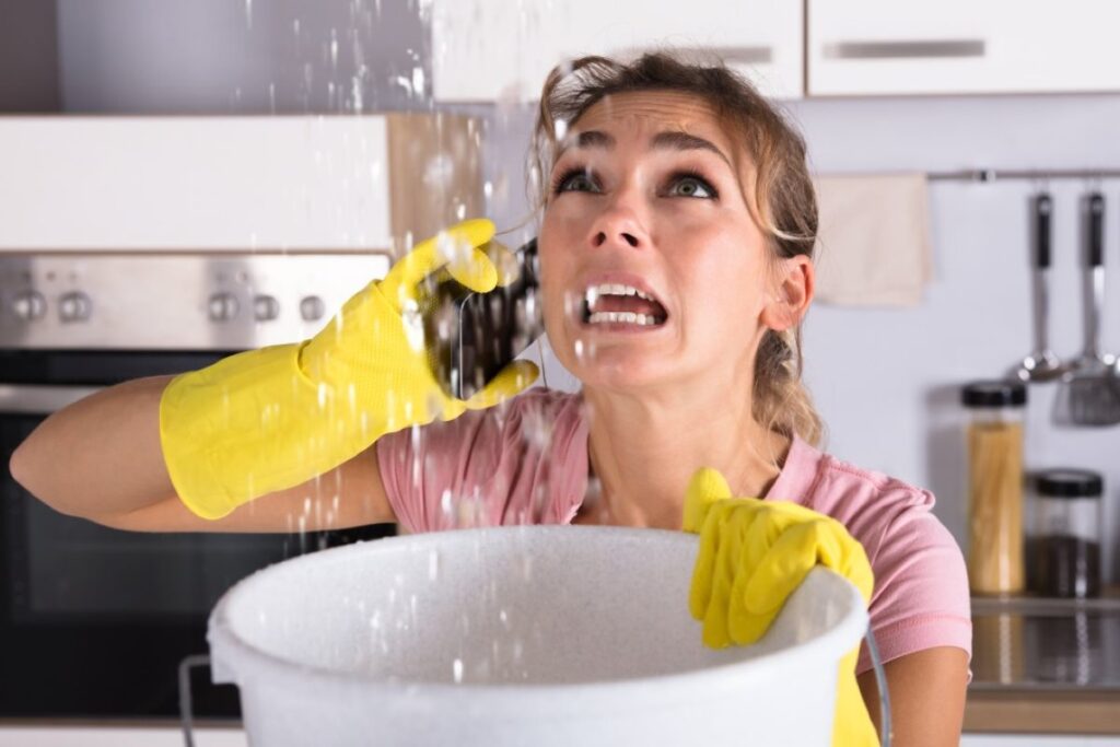 Woman trying to salvage a leaky roof in her kitchen