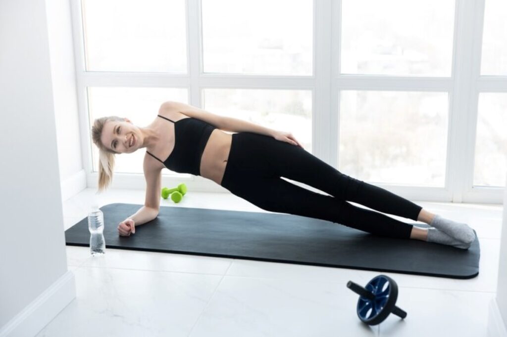 European sportswoman doing exercise on fitness mat