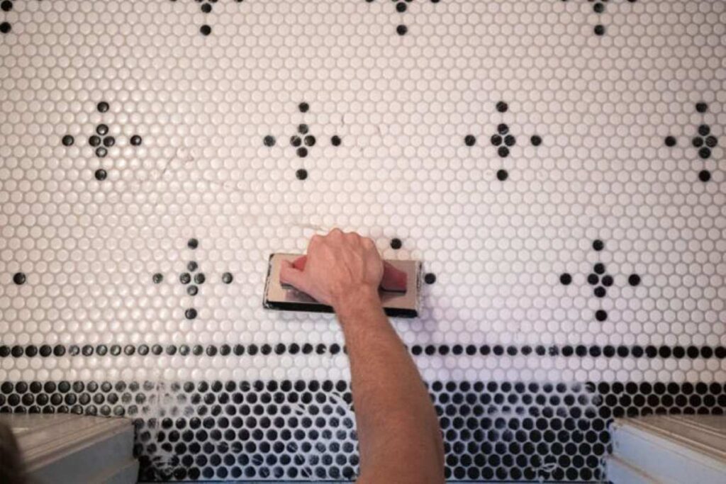 A tiler putting finishing touches to a tile installation