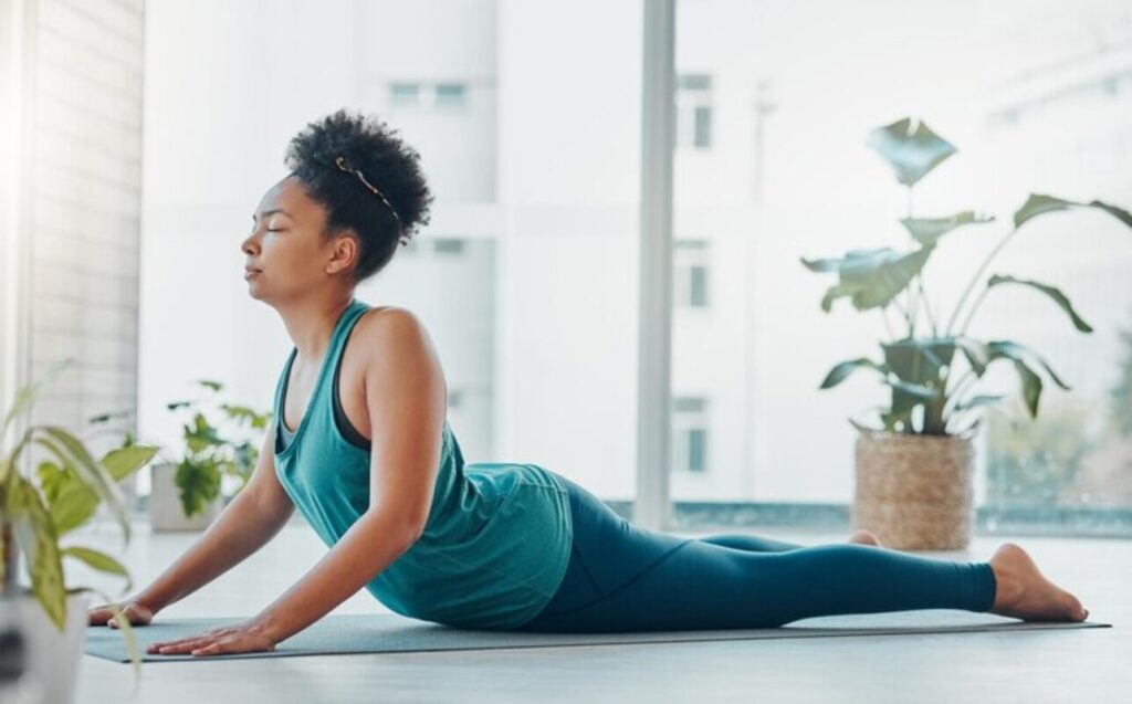 A lady having a yoga session in her living room