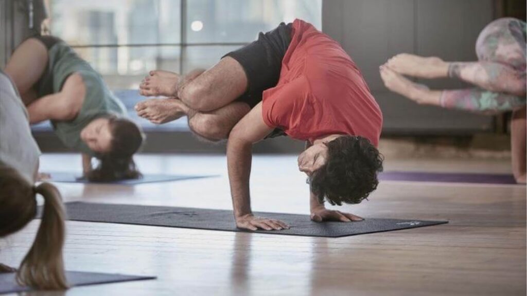 People at the gym streching on a workout mat