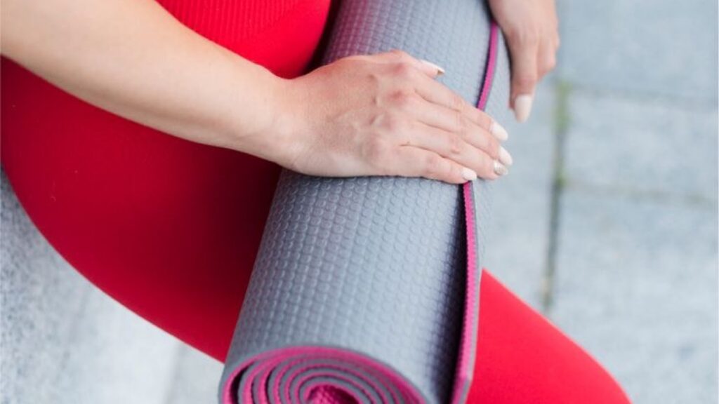 Woman holding a workout mat