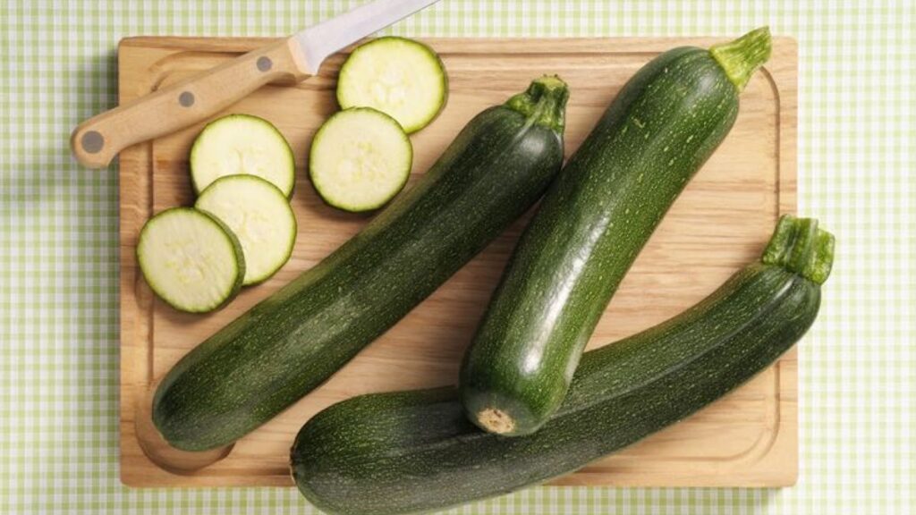 Zucchini on a wooden tray with a knife