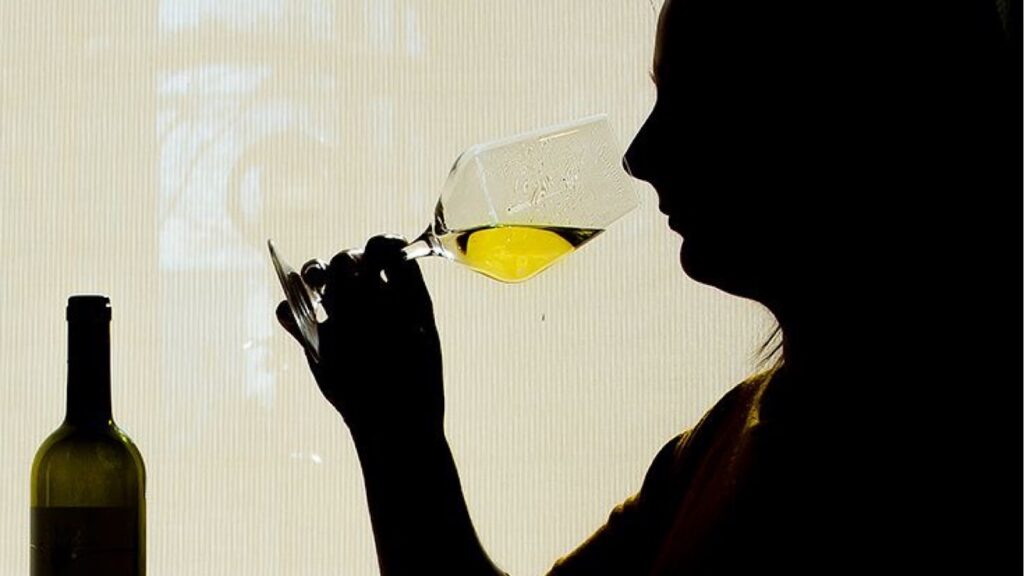 Person perceiving wine form a wine glass