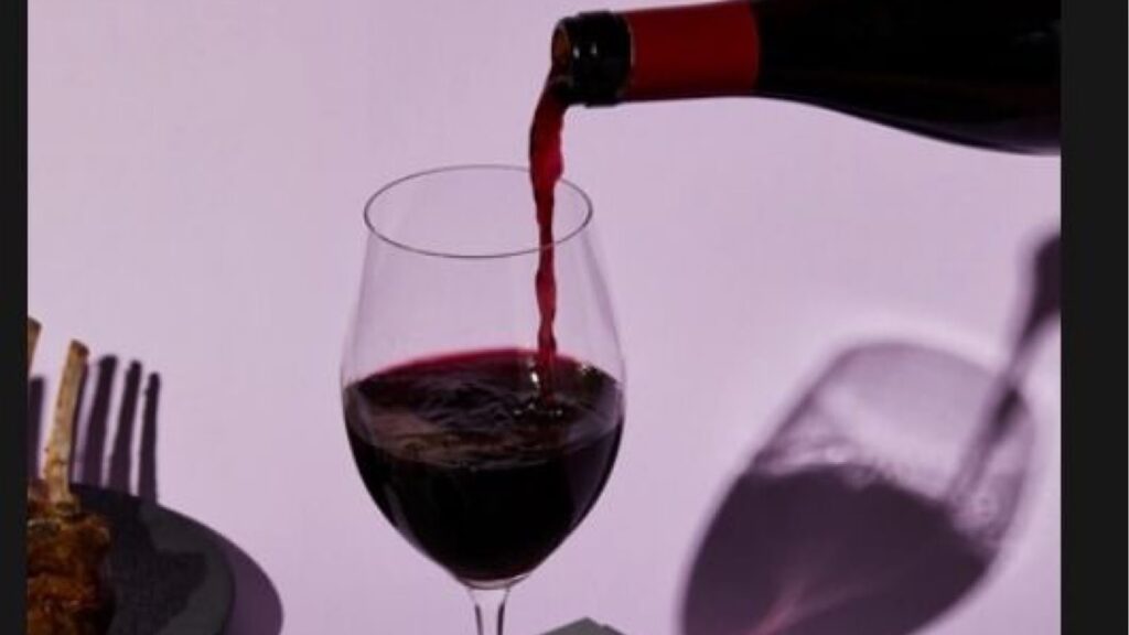 Person pouring wine into a wine glass